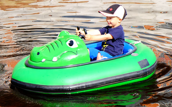 Pojke åker elbåt på Leksand sommarland.